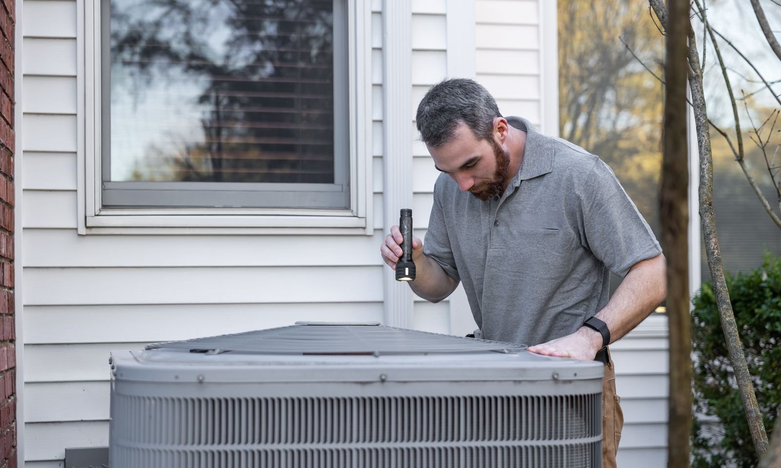 A technician checking a home air conditioning unit
